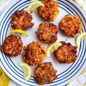 salmon croquettes on plate with lemon wedges.