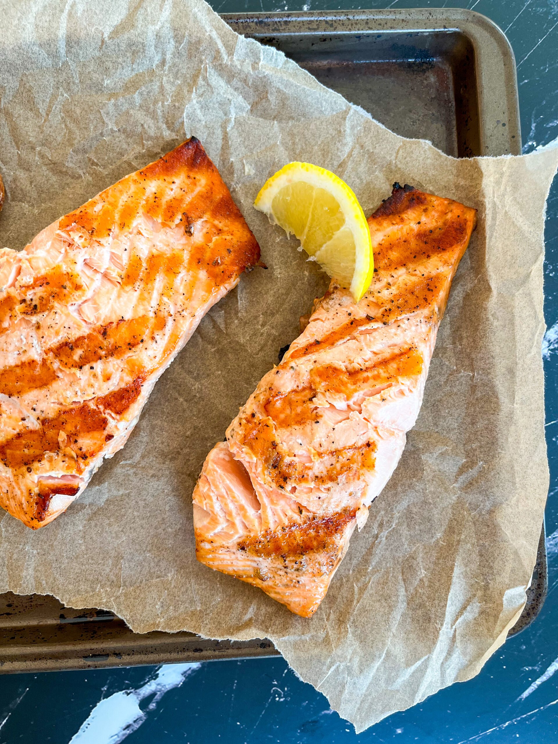 Over the top shot of grilled salmon fillets with lemon wedge