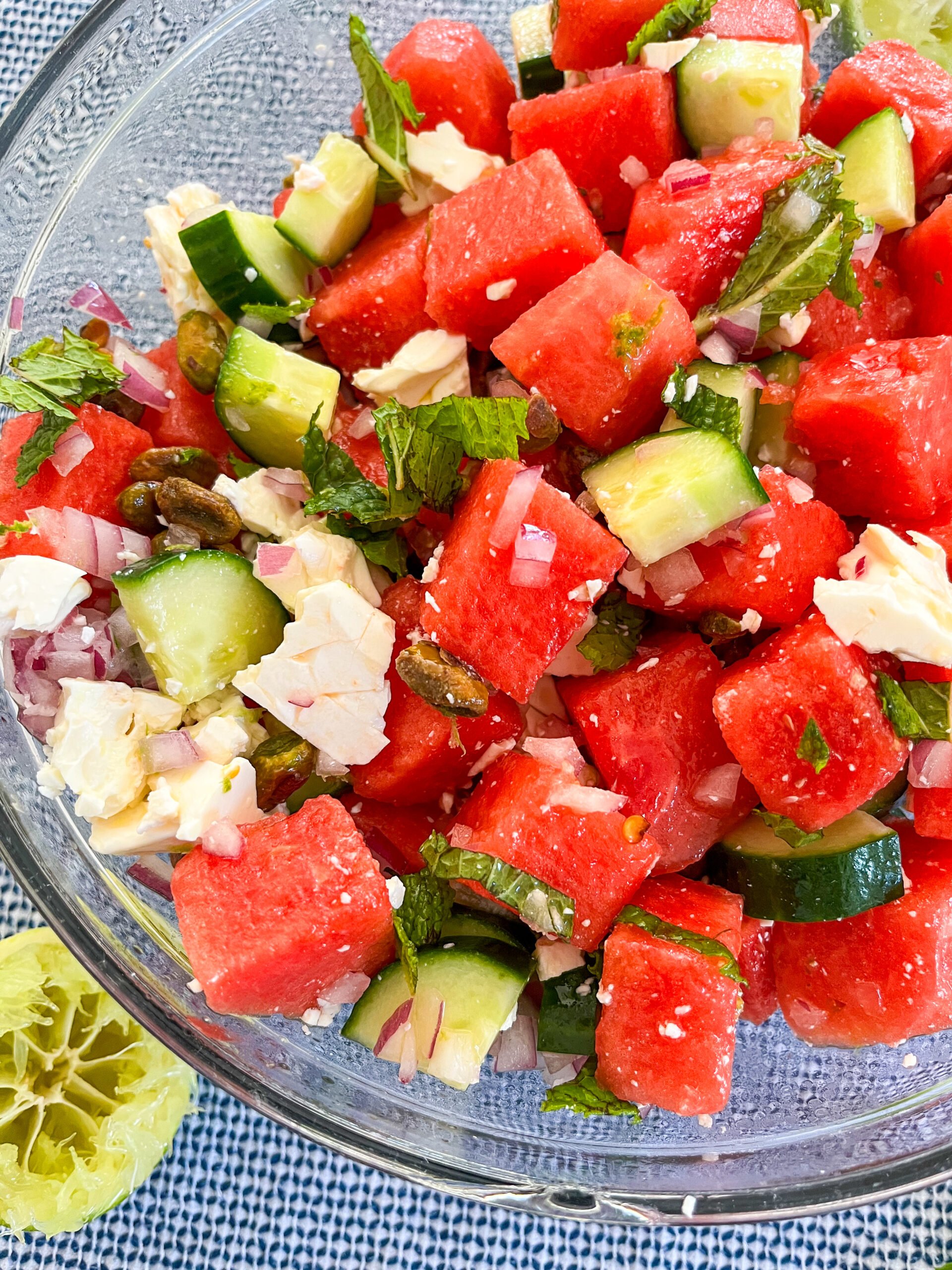 Close up of watermelon feta salad tossed in a clear bowl