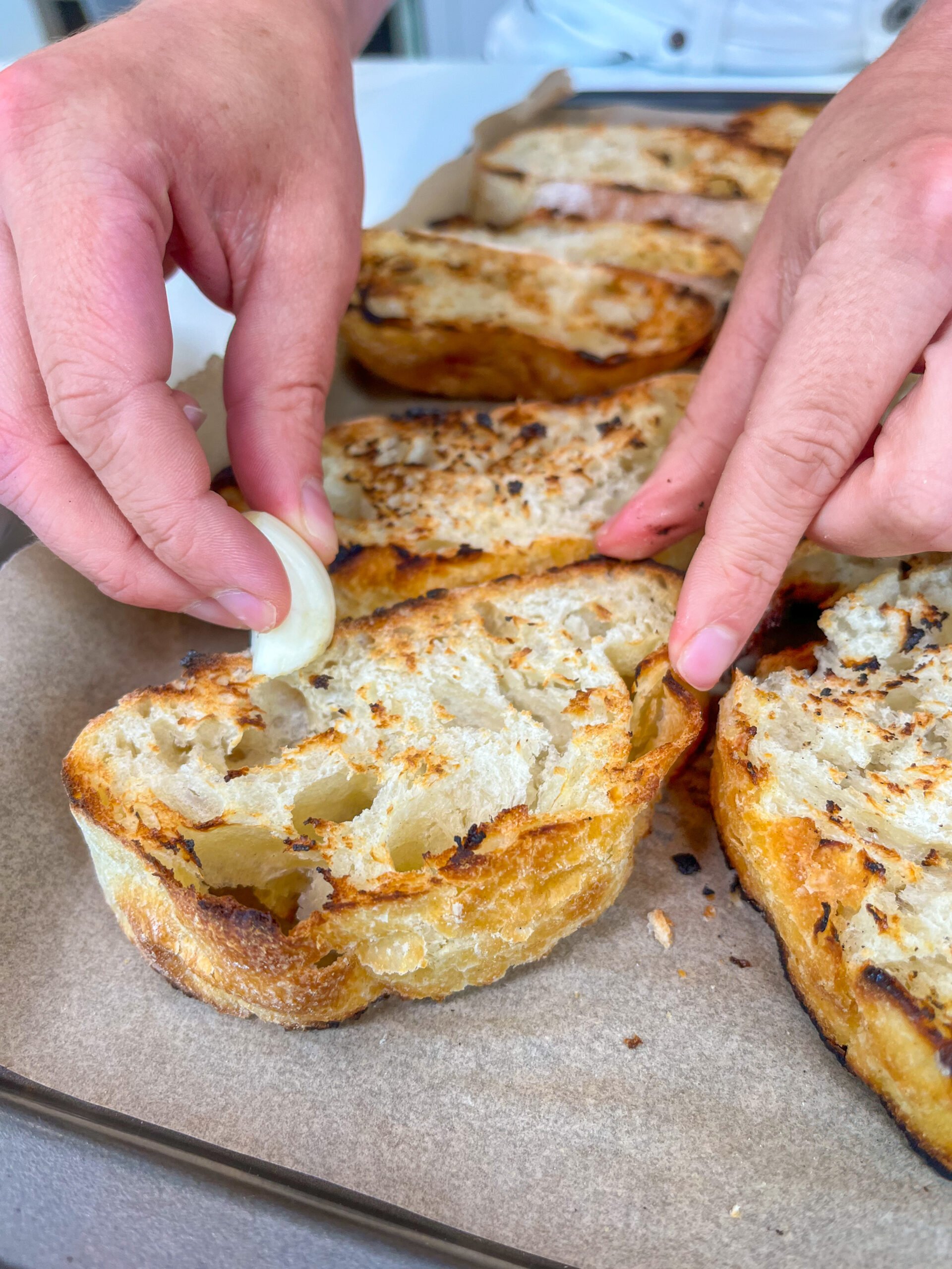 Rubbing a garlic clove on grilled bread