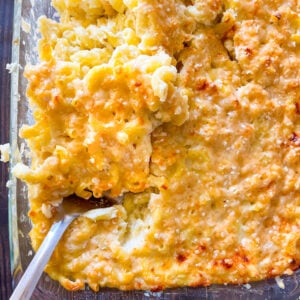 Homemade mac and cheese in glass pan with a large spoon
