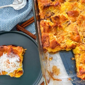 Bread pudding sliced on a plate with whipped cream