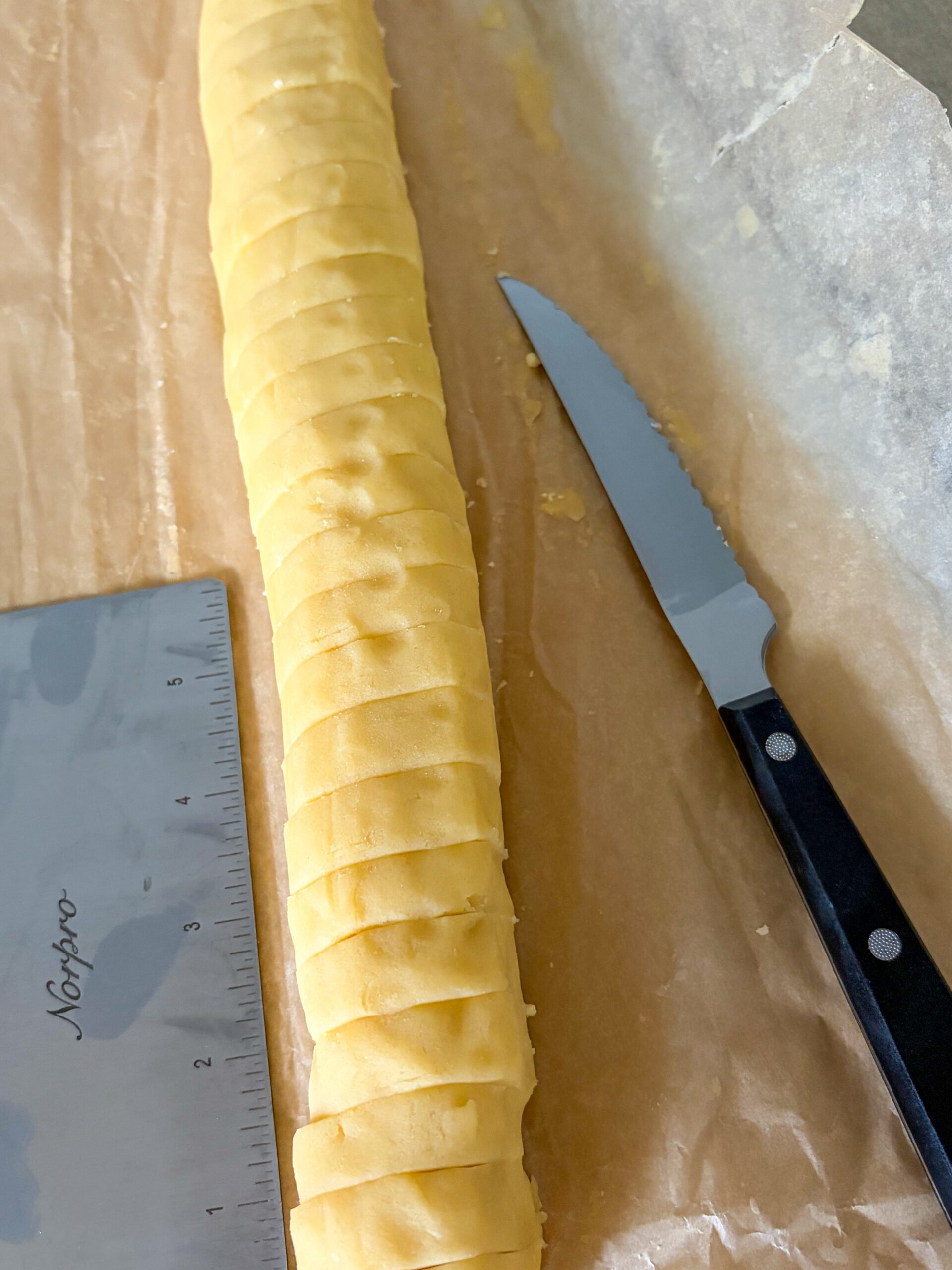 Slicing cookie dough log with knife