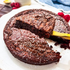 Flourless chocolate cake slice close up over the rest of the cake
