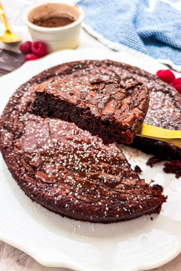 Flourless chocolate cake slice close up over the rest of the cake