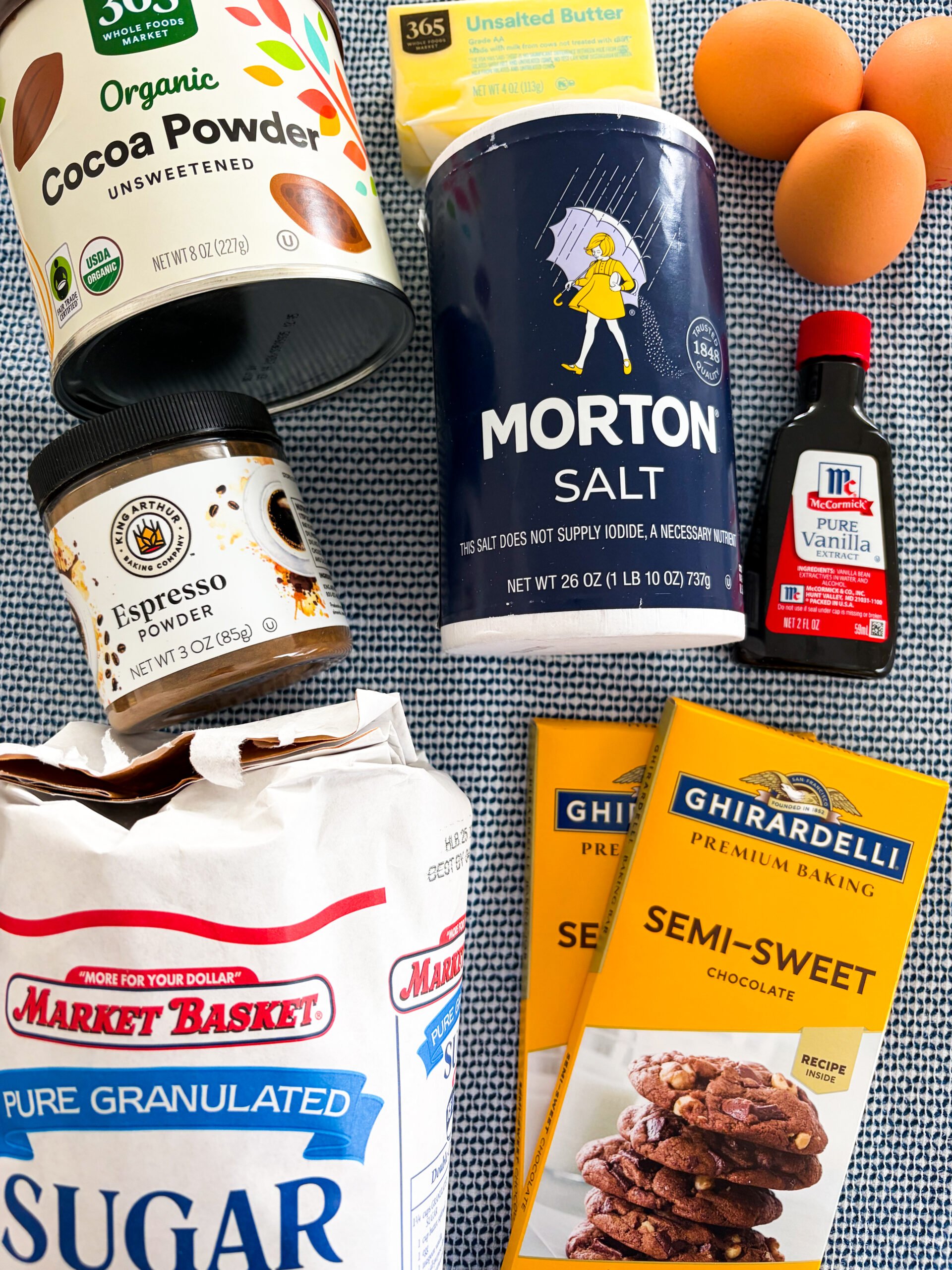 Flourless chocolate cake ingredients laid out on a blue and white dish towel