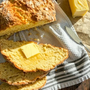 Irish soda bread sliced with butter on a towel