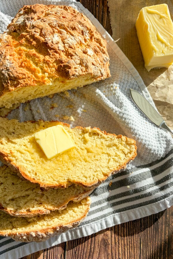 Irish soda bread sliced with butter on a towel