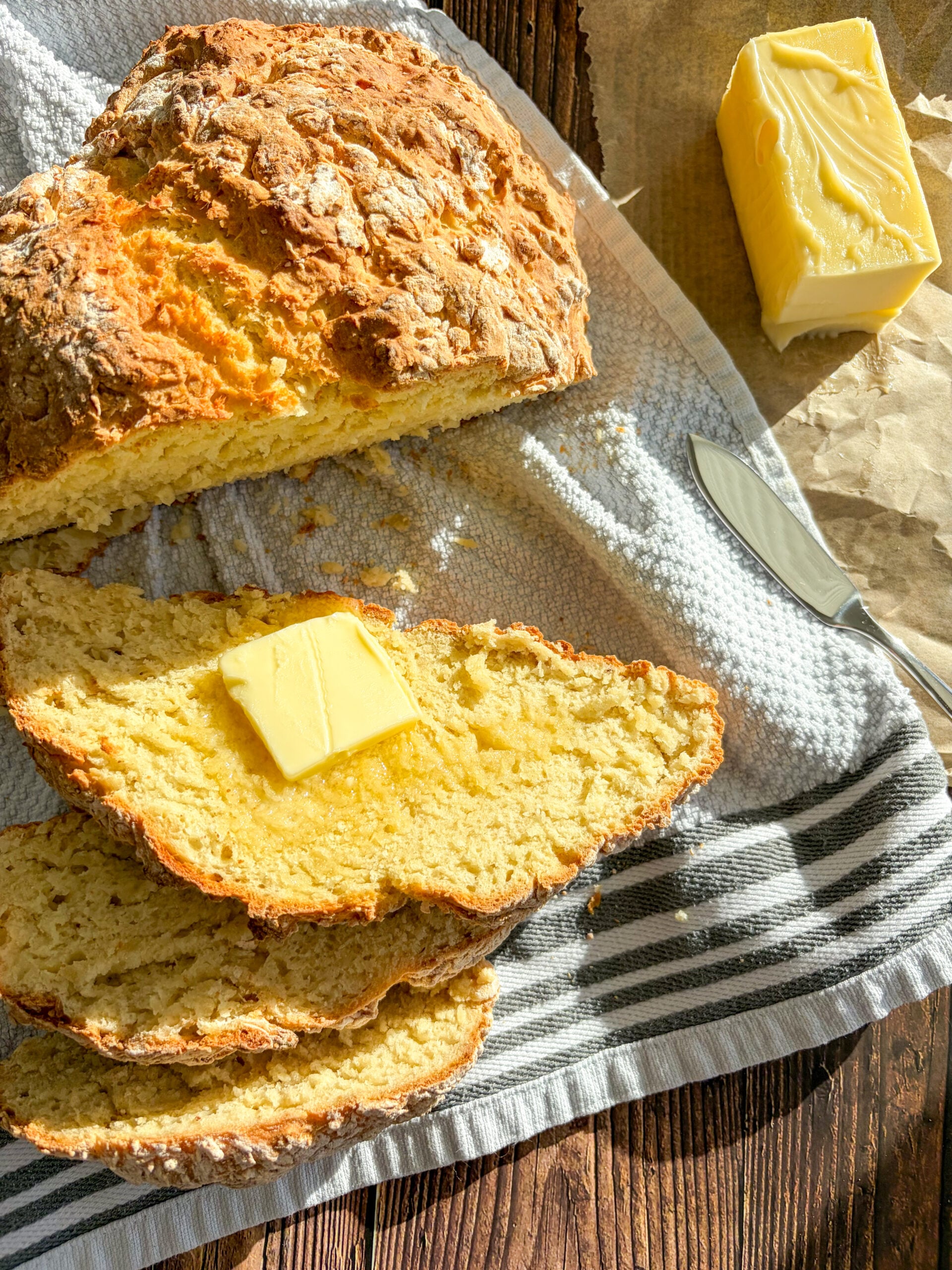 Irish soda bread sliced with butter on a towel