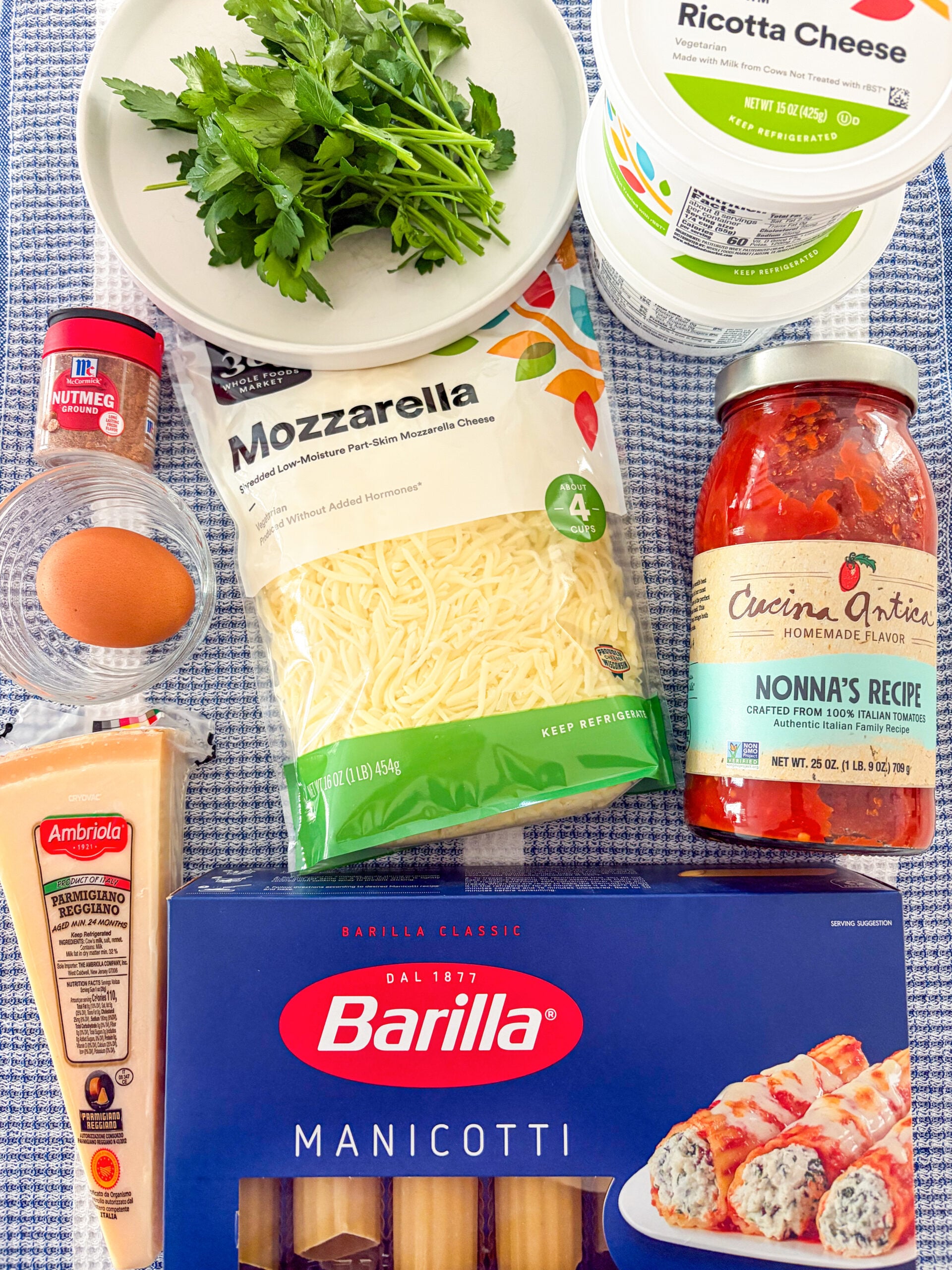 Manicotti ingredients laid out on blue and white dish towel