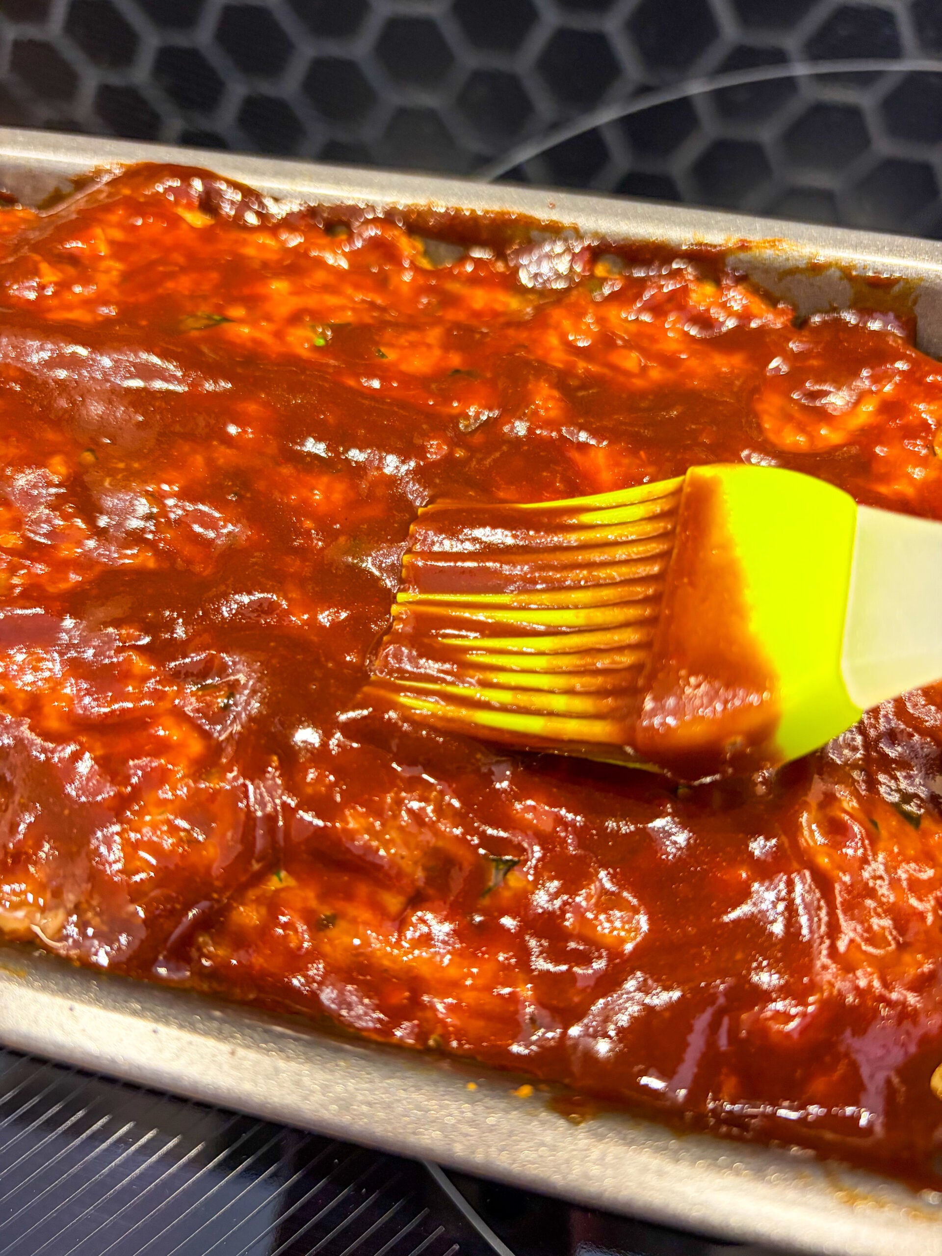 Meatloaf being brushed with glaze