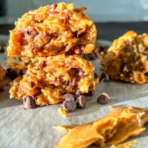 Protein balls broken in half on a piece of parchment with a smear of peanut butter