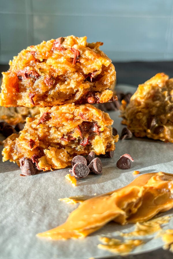 Protein balls broken in half on a piece of parchment with a smear of peanut butter