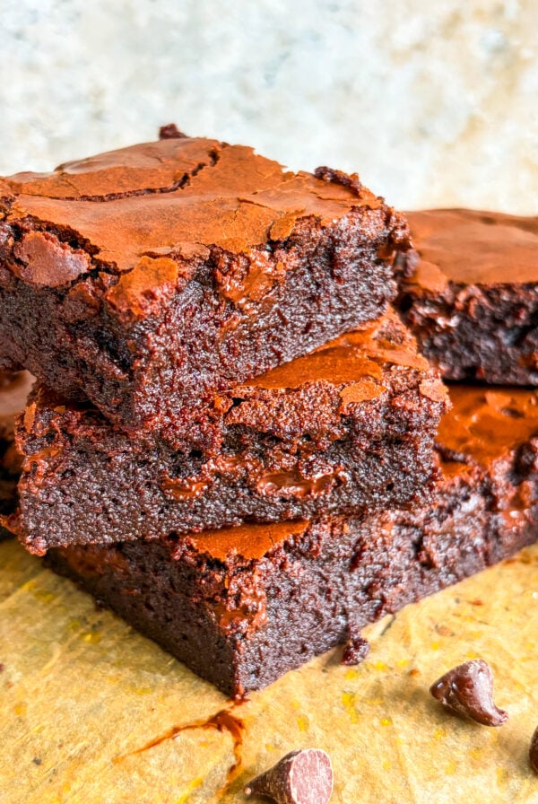 Brownie slices stacked close up on parchment