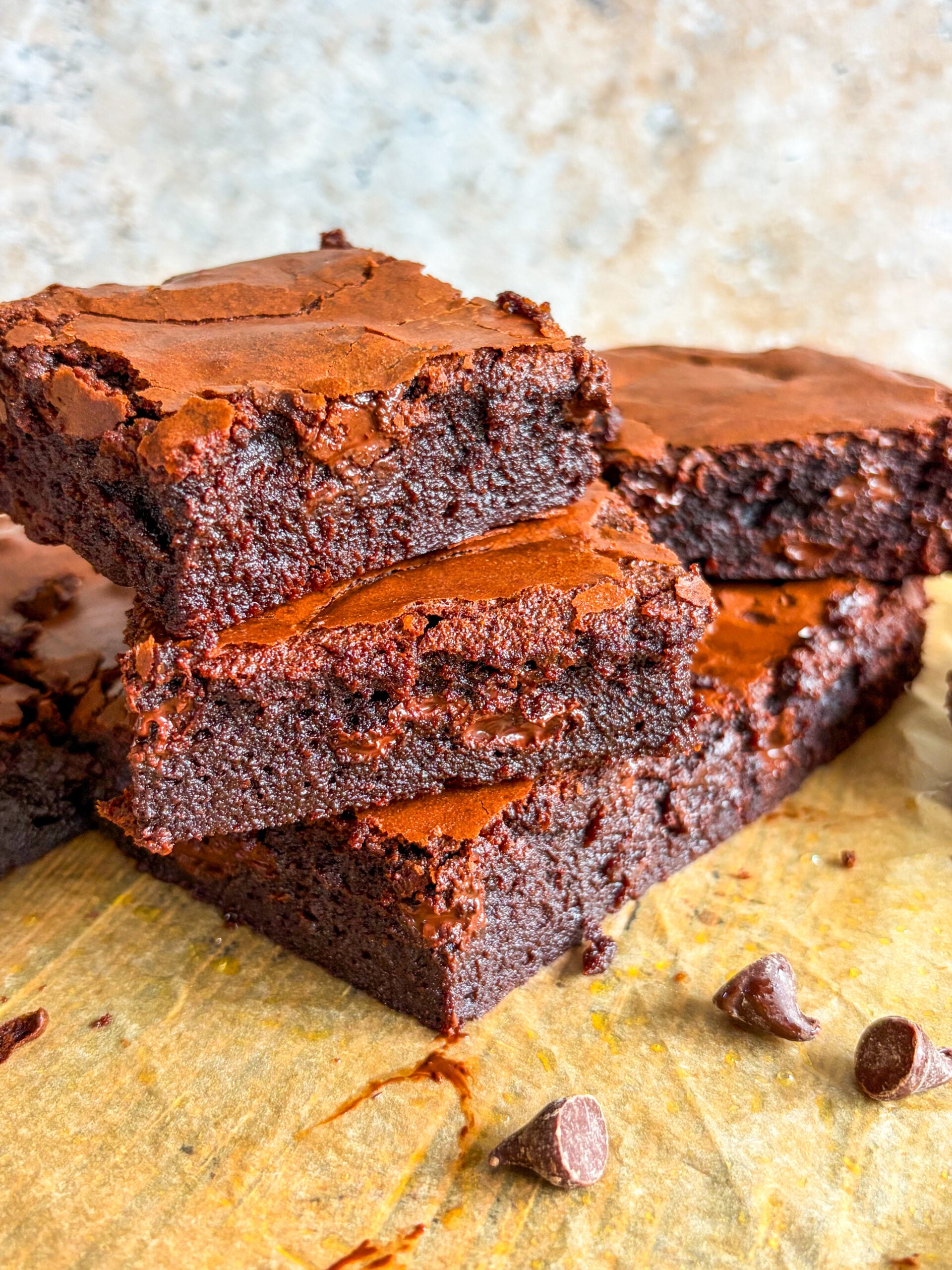 Brownie slices stacked on each other on parchment