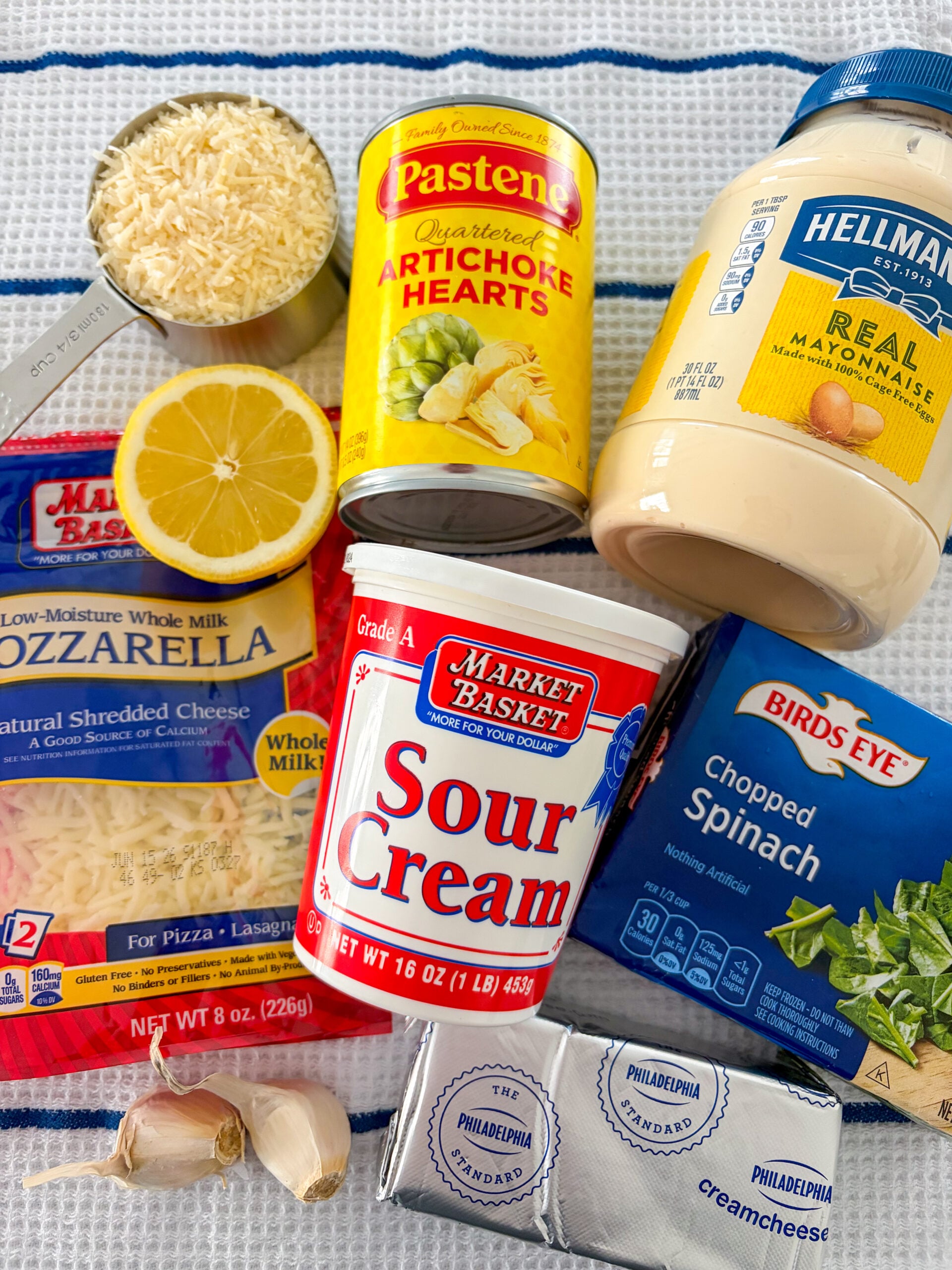 Spinach artichoke dip ingredients on a blue and white dish towel