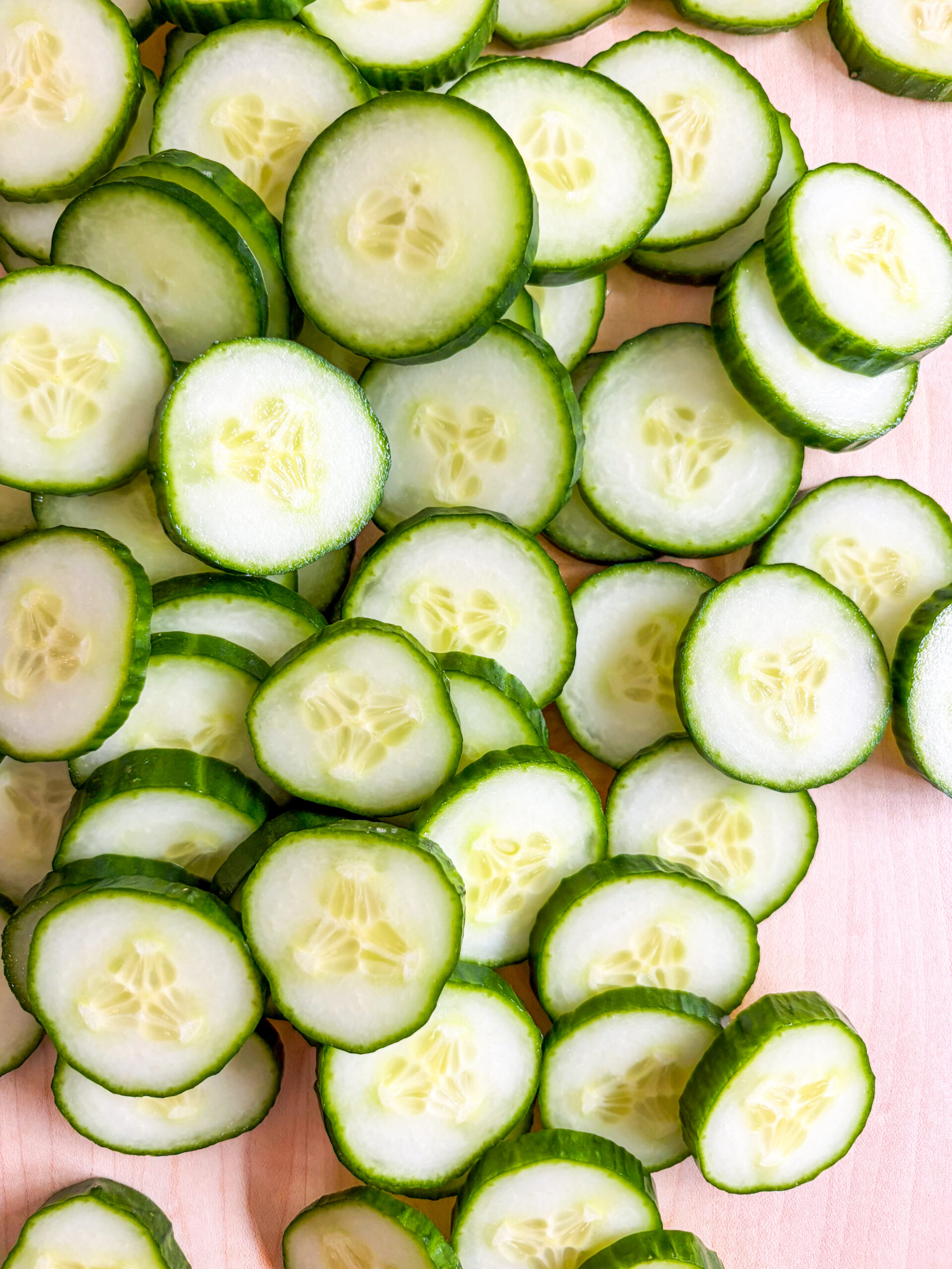 Sliced cucumber rounds on cutting board