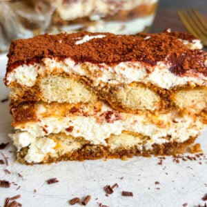Close up of tiramisu slice on white plate