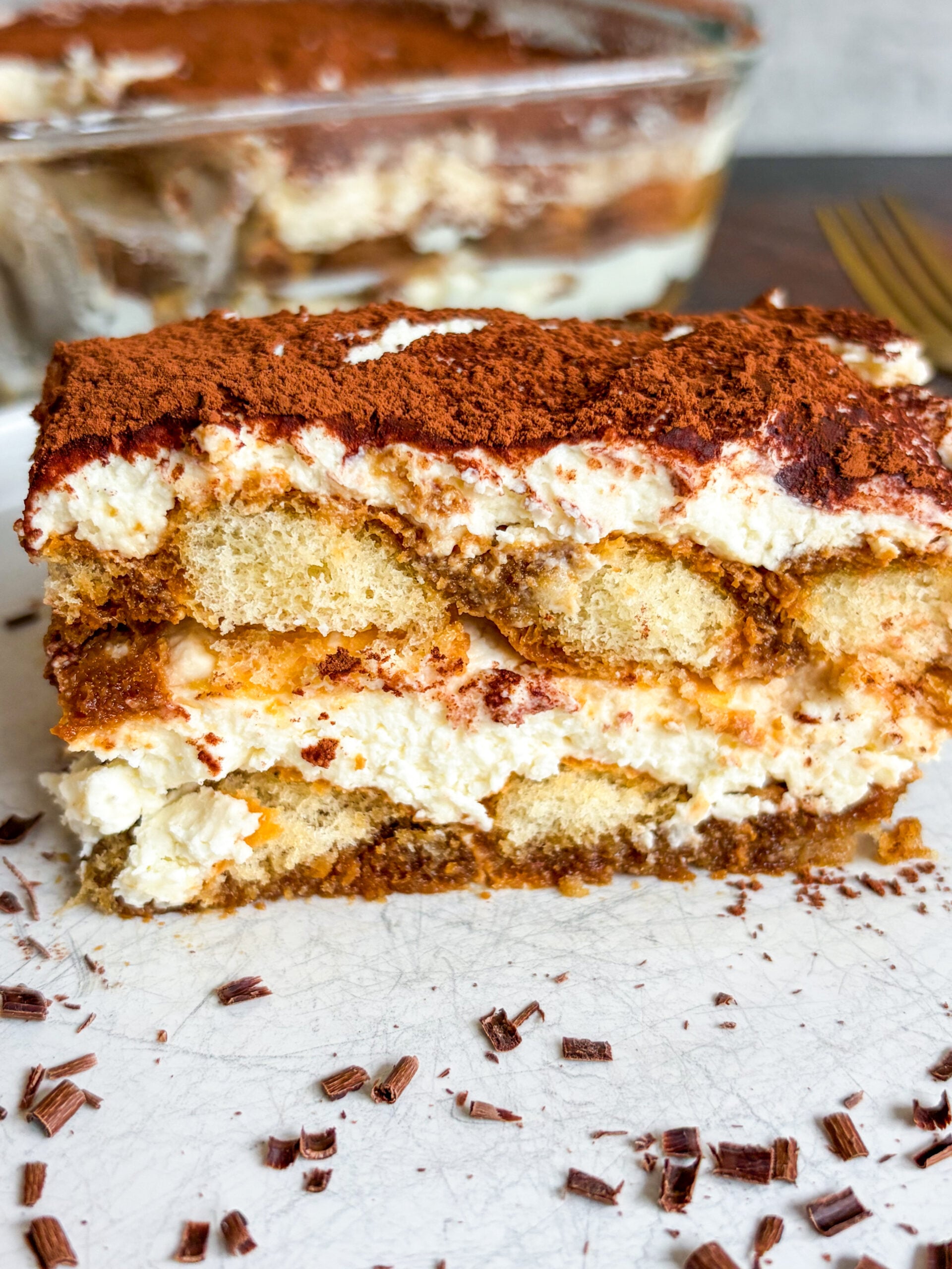 Close up of tiramisu slice on white plate