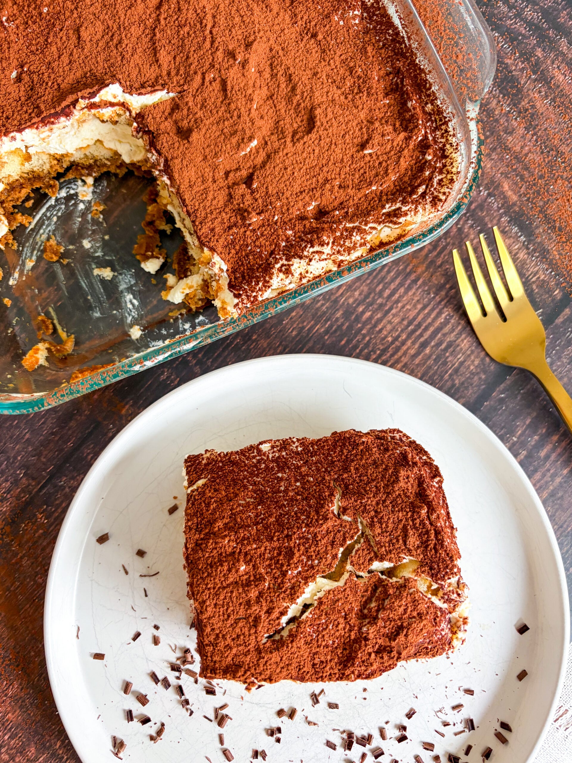 Over top shot of tiramisu slice next to pan of tiramisu