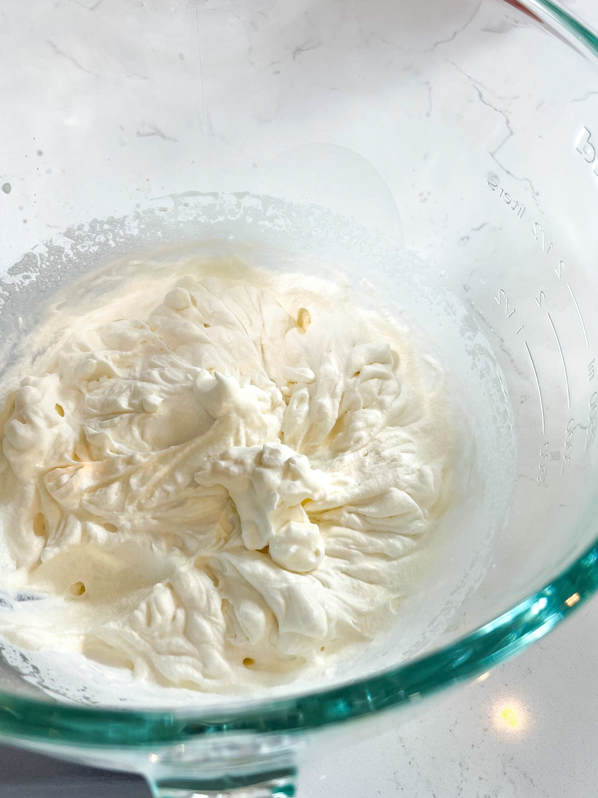 Cream whipped to medium peaks in glass bowl