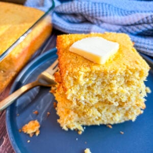 Slices of cornbread stacked with slab of butter on top