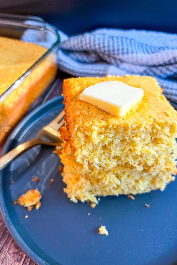 Slices of cornbread stacked with slab of butter on top