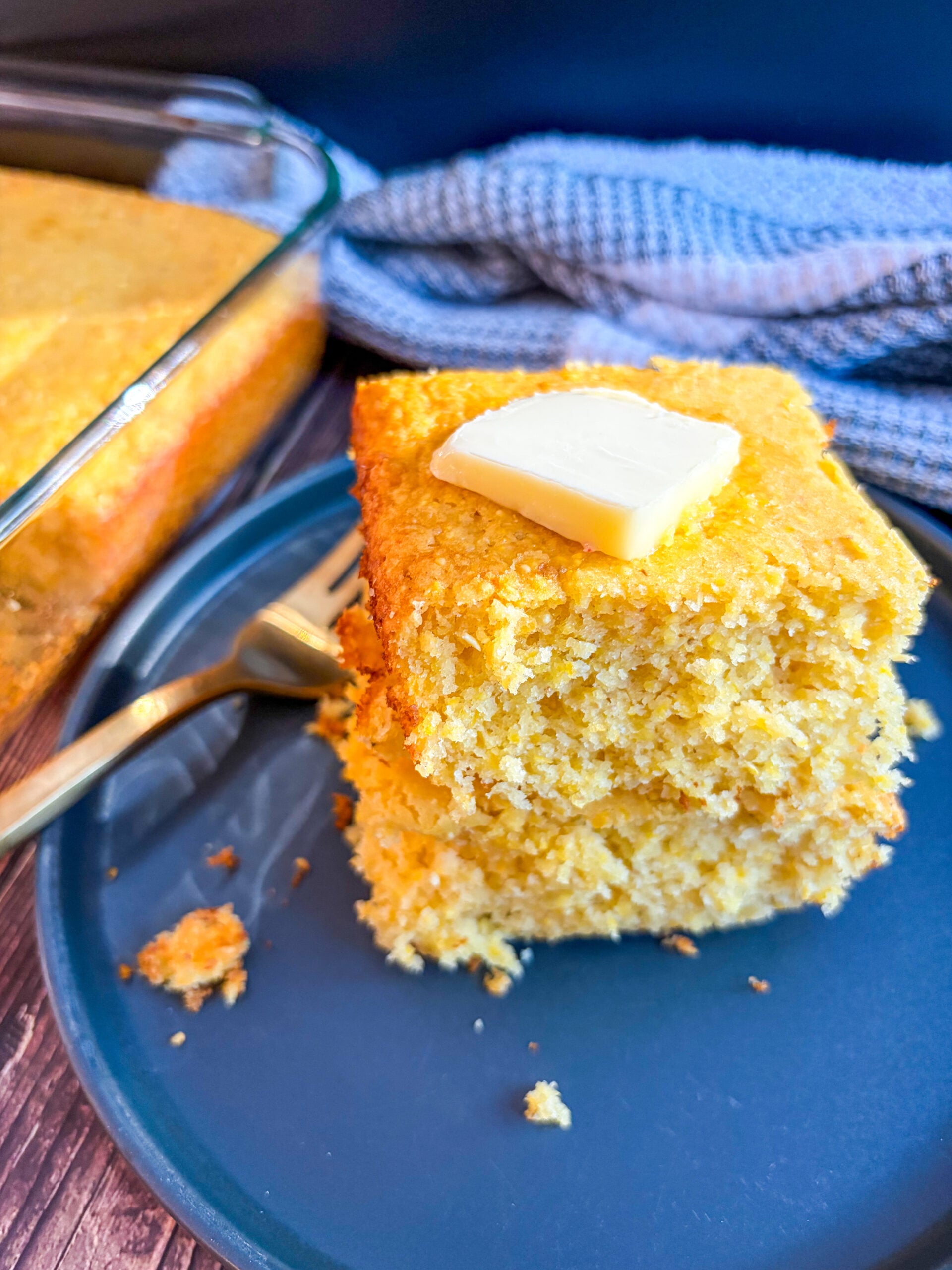 Slices of cornbread stacked with slab of butter on top