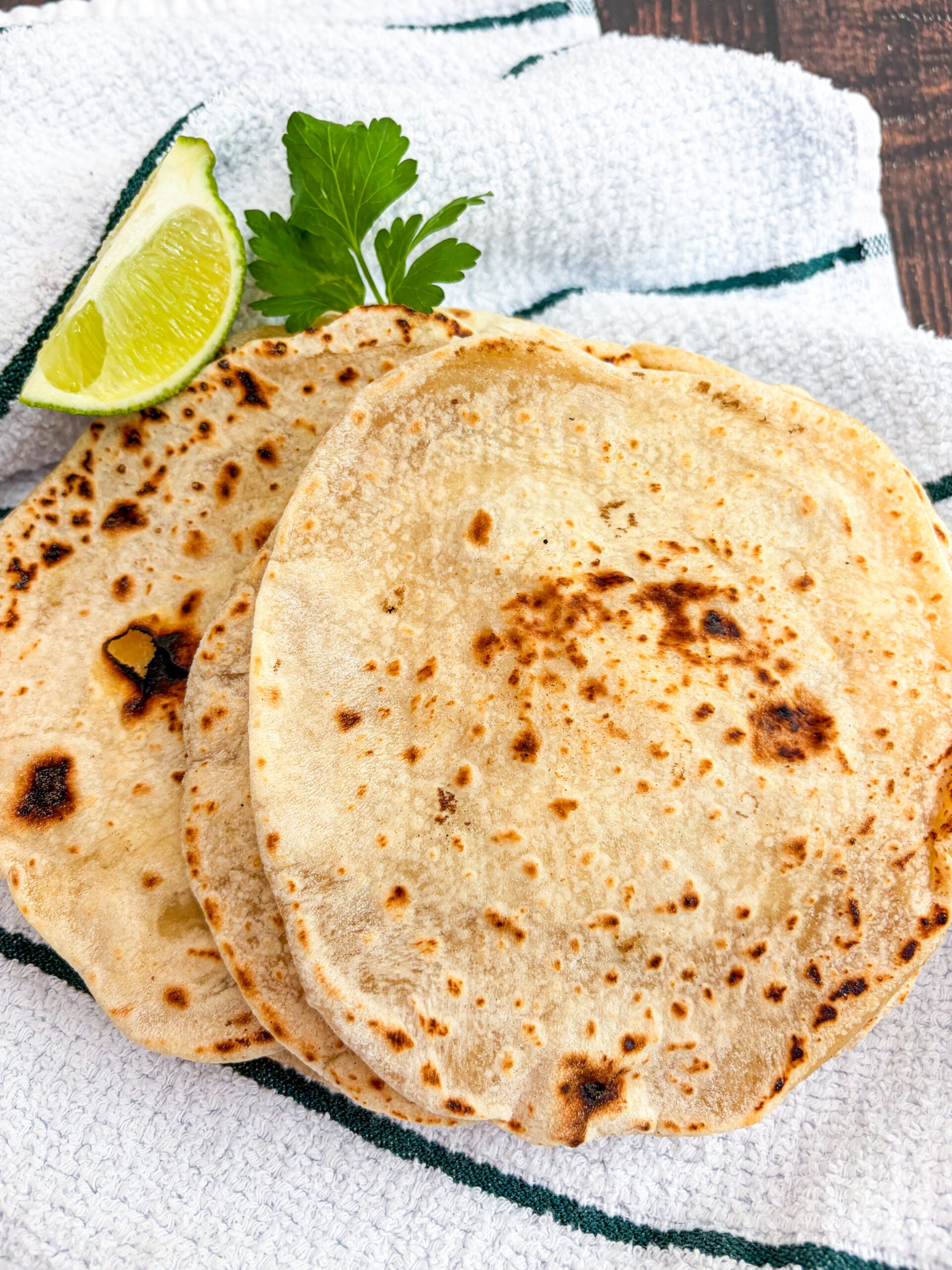 Flour tortillas stacked on a dish towel