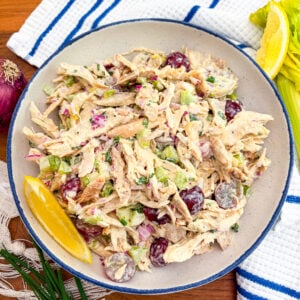 Chicken salad in a blue and white bowl garnished with lemon wedge