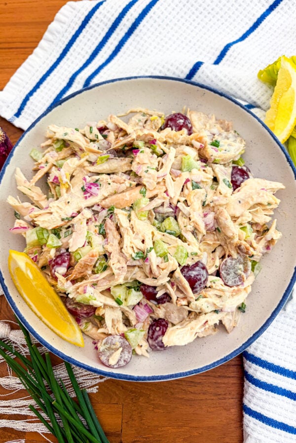 Chicken salad in a blue and white bowl garnished with lemon wedge