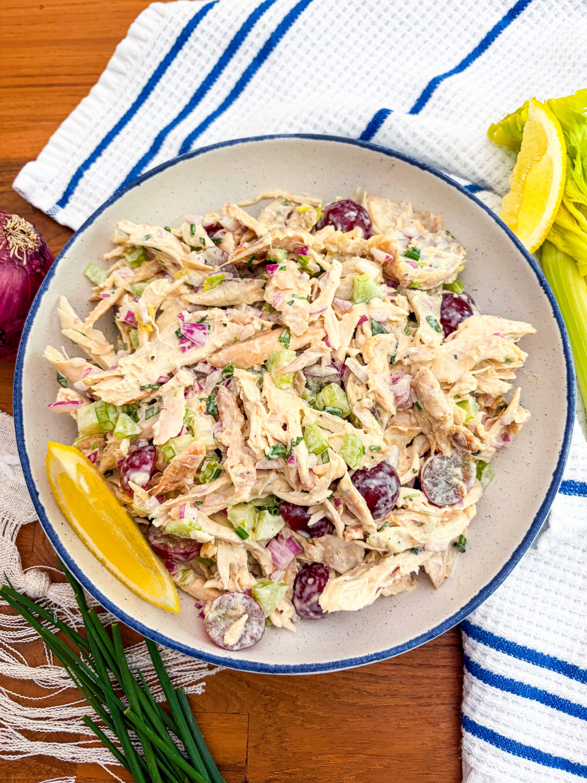 Chicken salad in a blue and white bowl garnished with lemon wedge