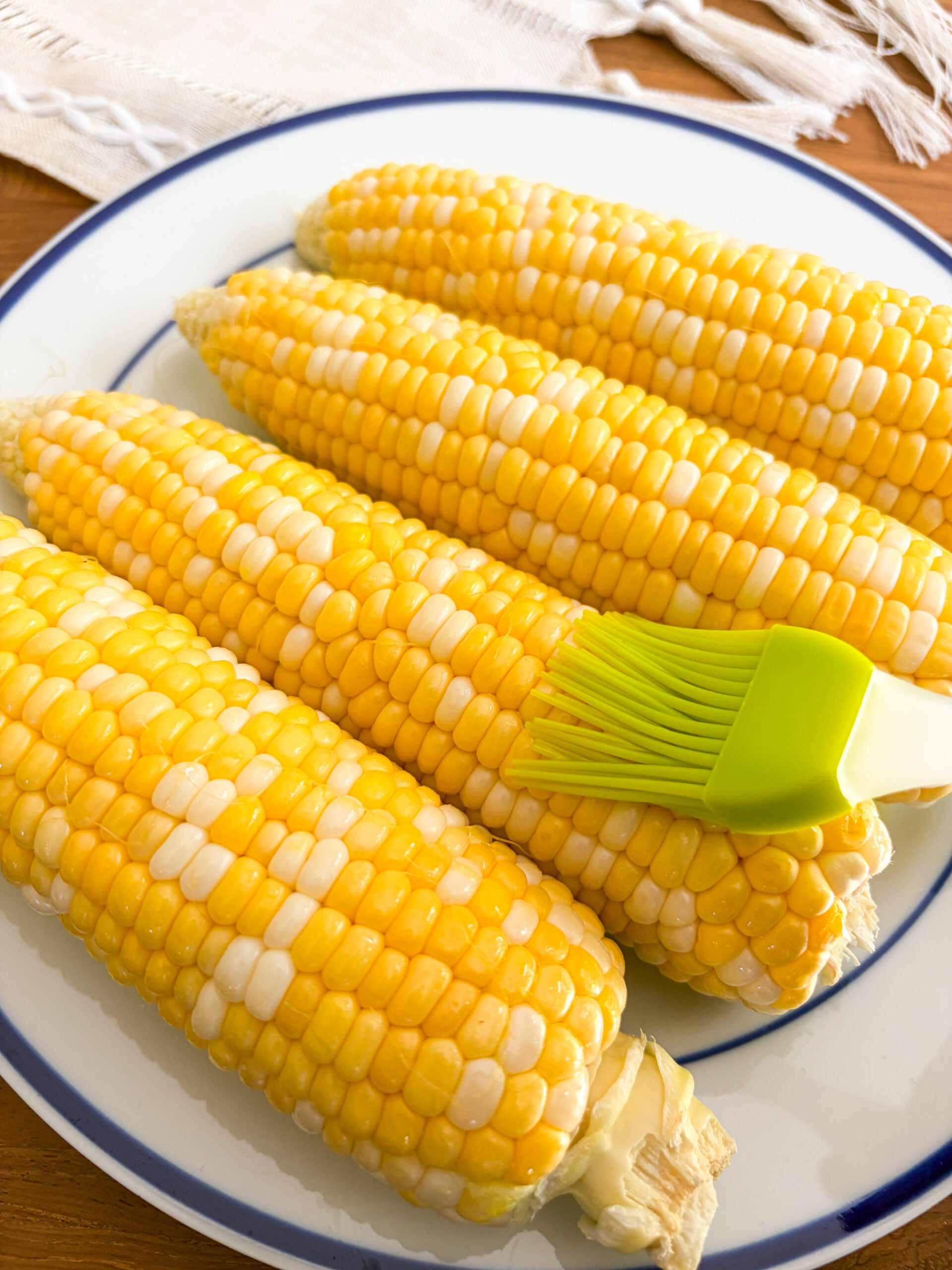 Brushing corn on the cob with butter or oil
