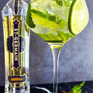 Hugo Spritz in a wine glass next to St-Germain bottle