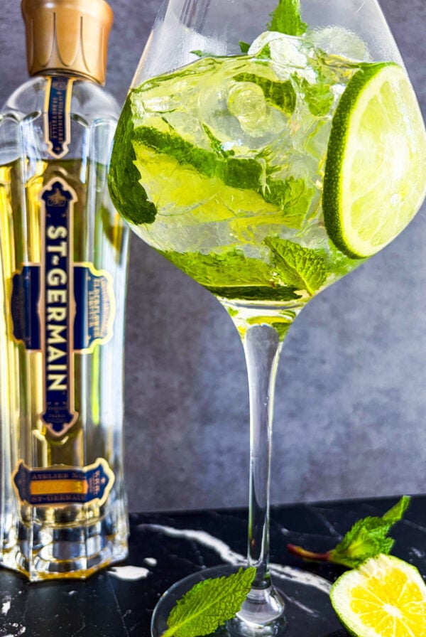 Hugo Spritz in a wine glass next to St-Germain bottle