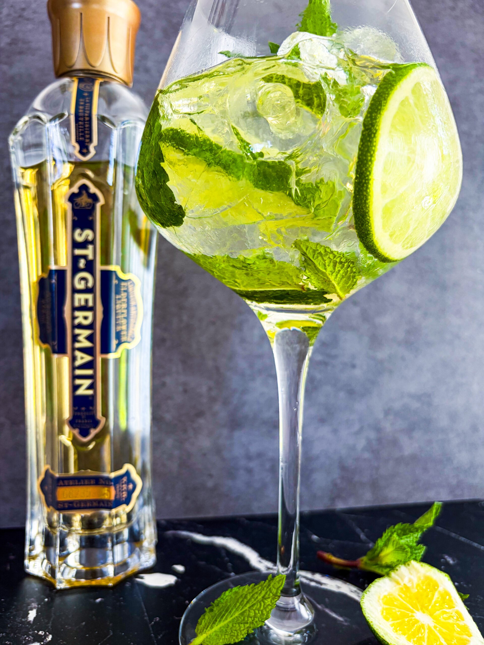 Hugo Spritz in a wine glass next to St-Germain bottle