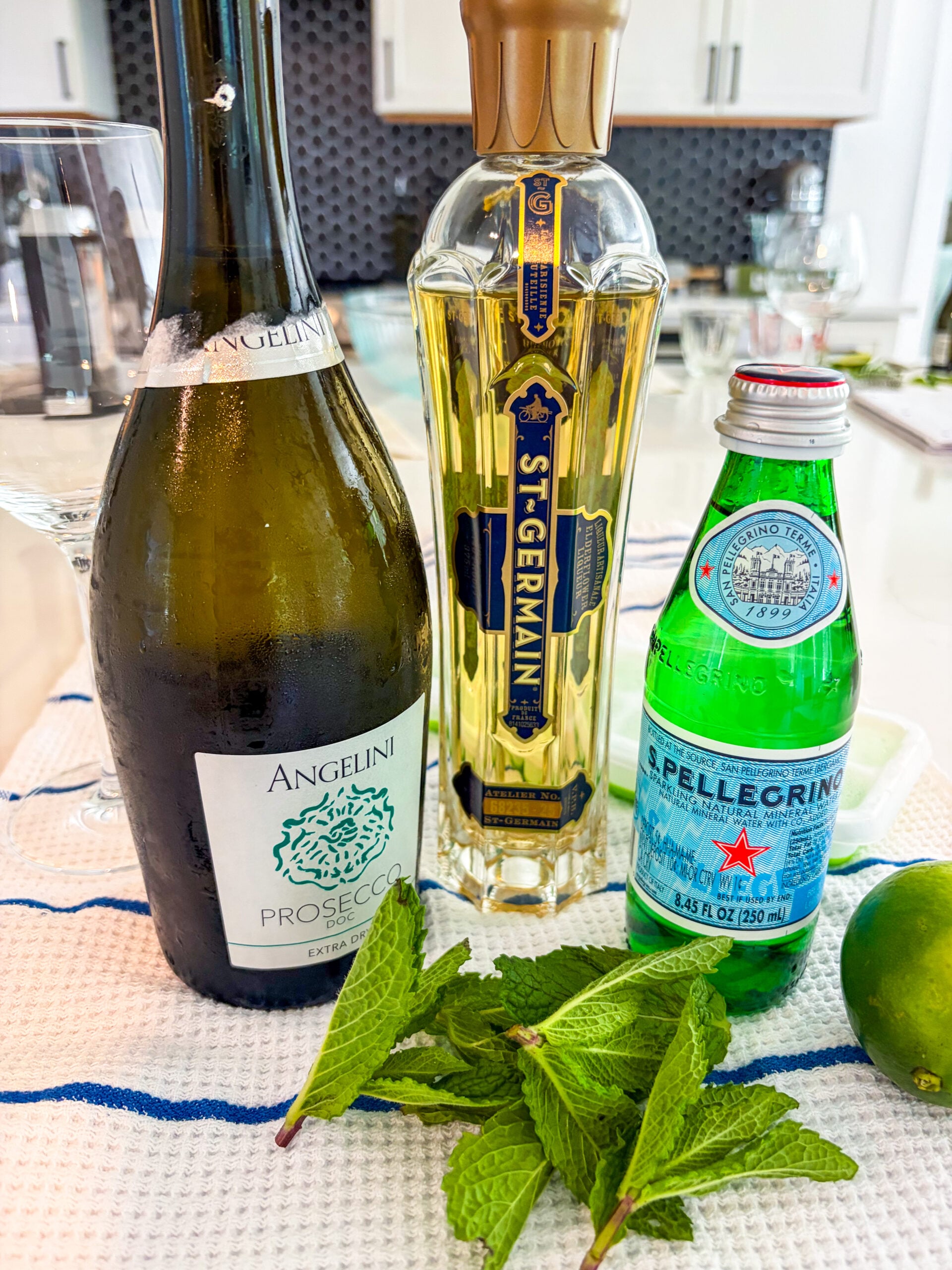 Hugo Spritz recipe ingredients laid out on a blue and white dish towel
