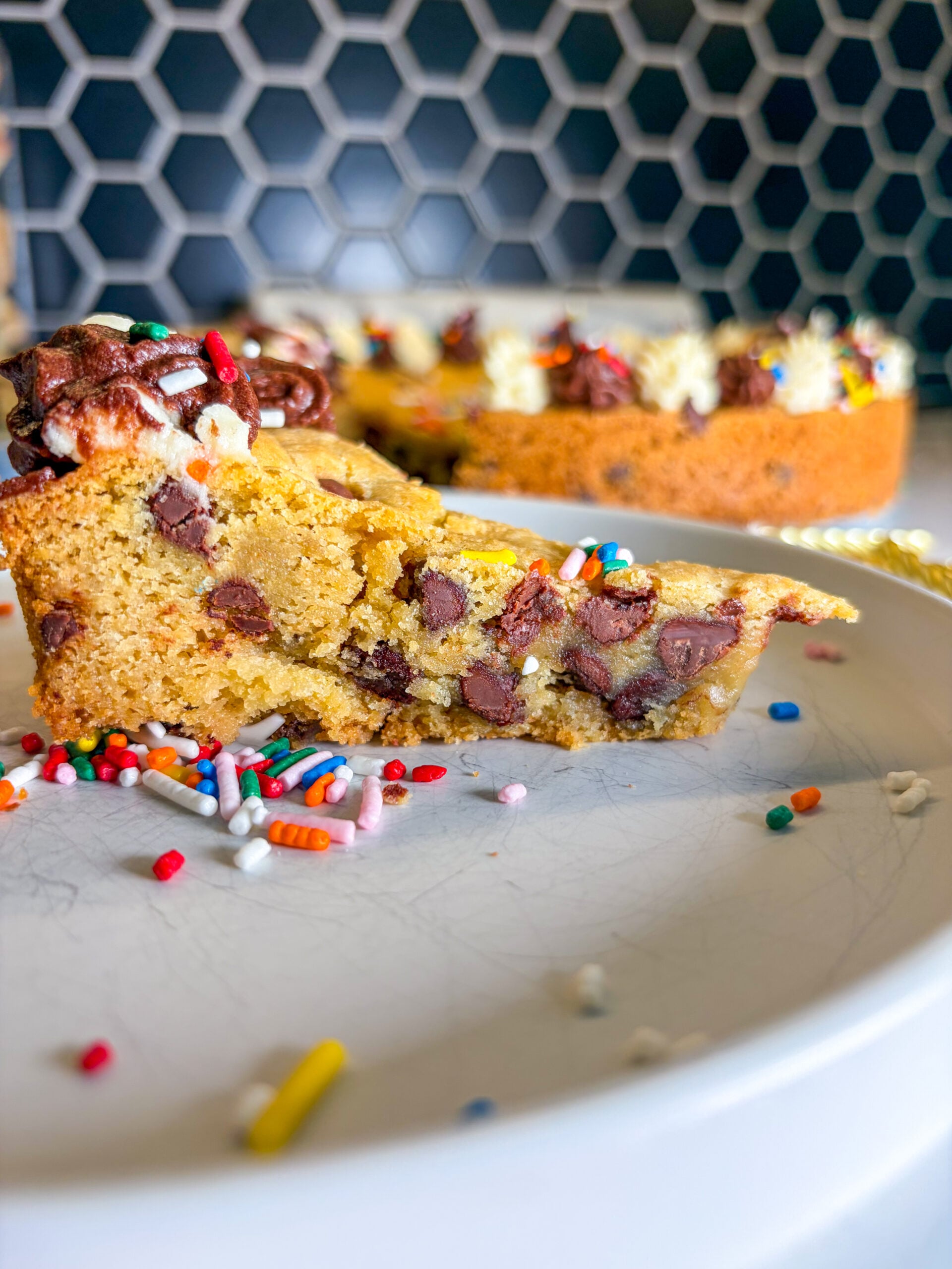 Close up side view of cookie cake slice garnished with sprinkles