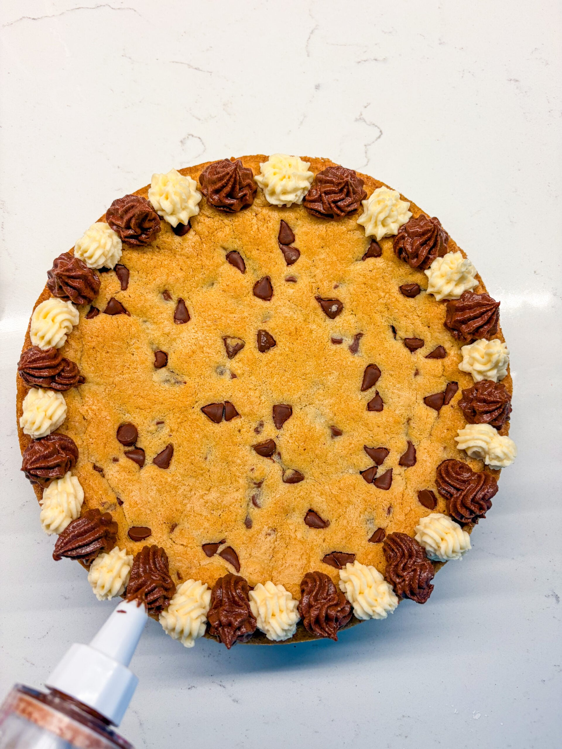 Frosting a cookie cake with a piping bag