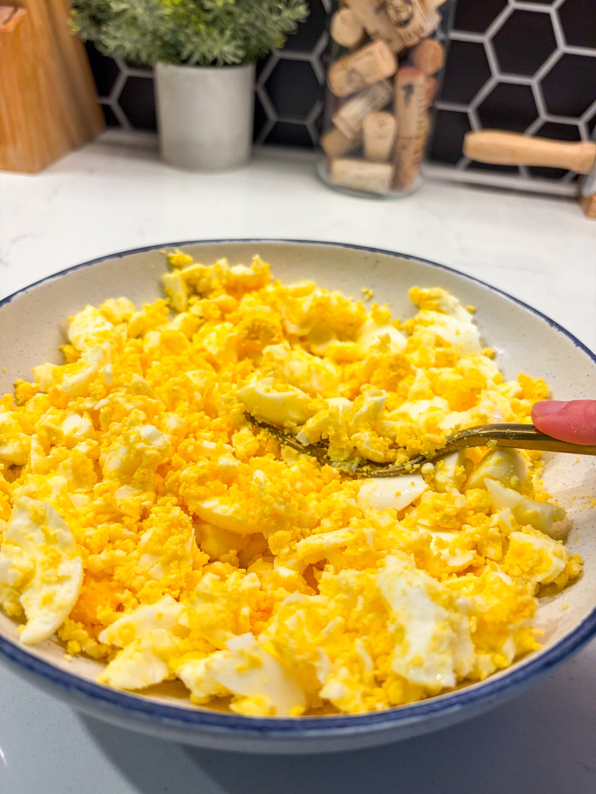 Mashed hard boiled eggs in a bowl with a fork