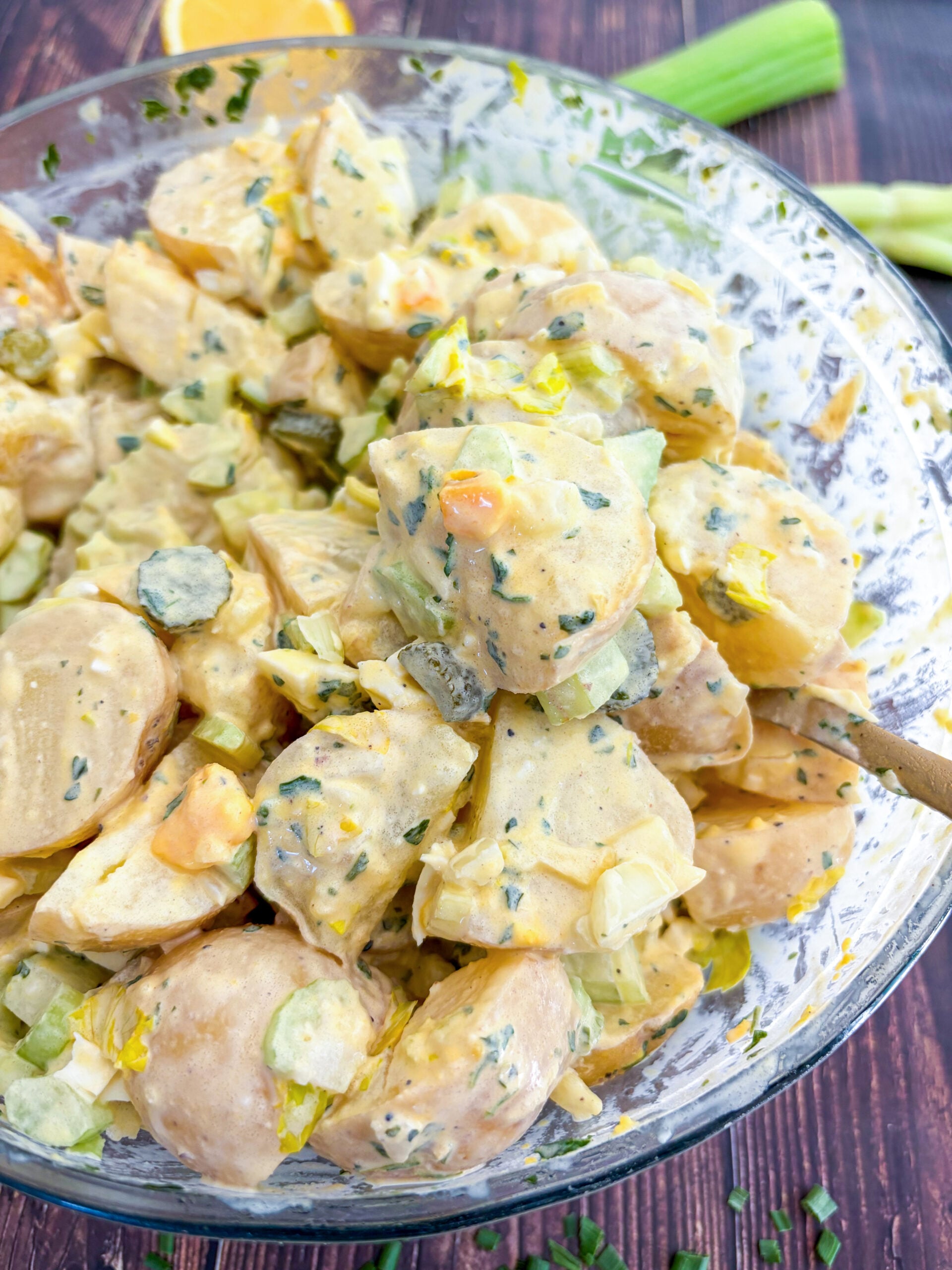 Tossed potato salad in a glass mixing bowl
