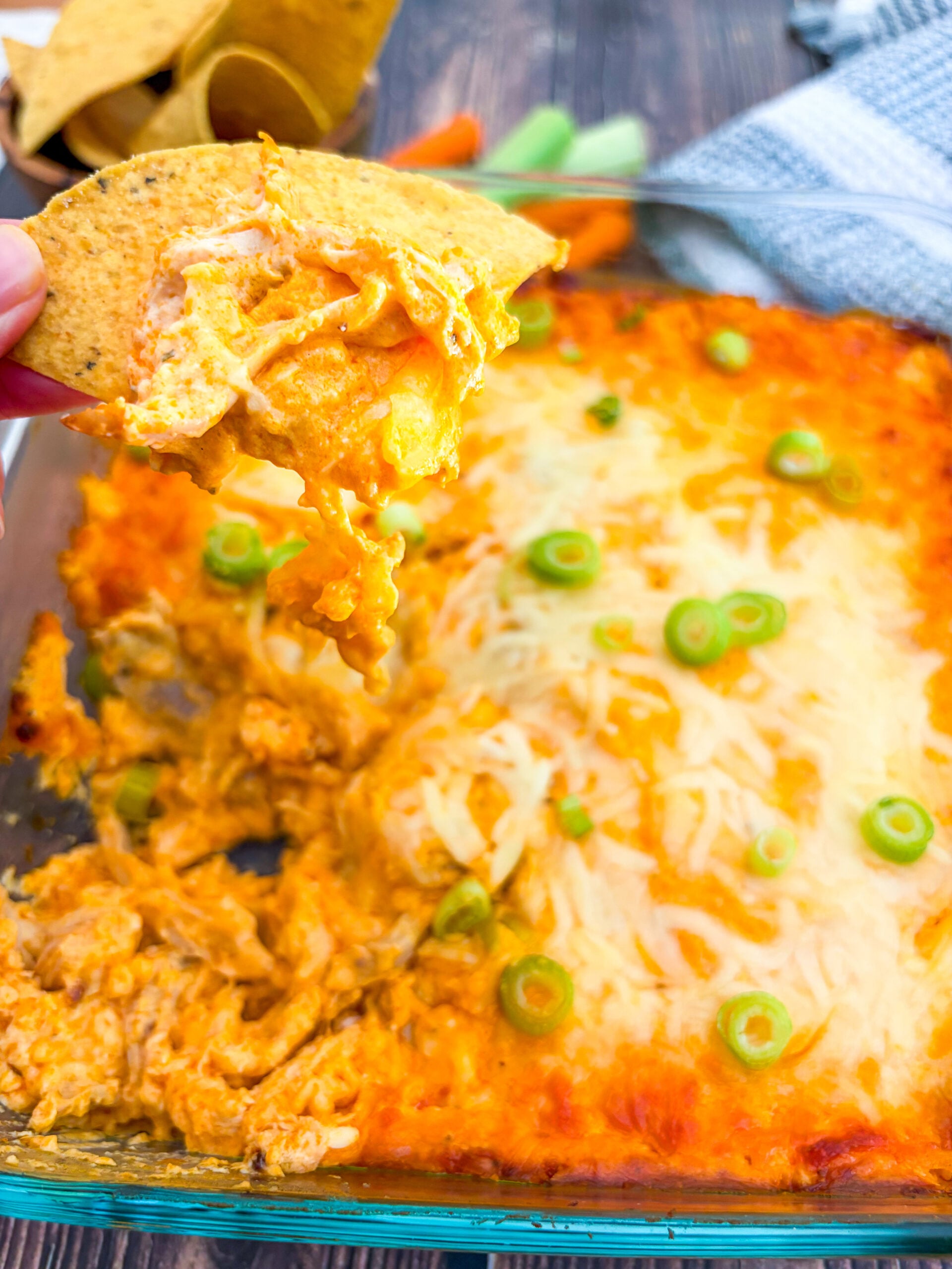 Close up of buffalo chicken dip scooped with tortilla chip