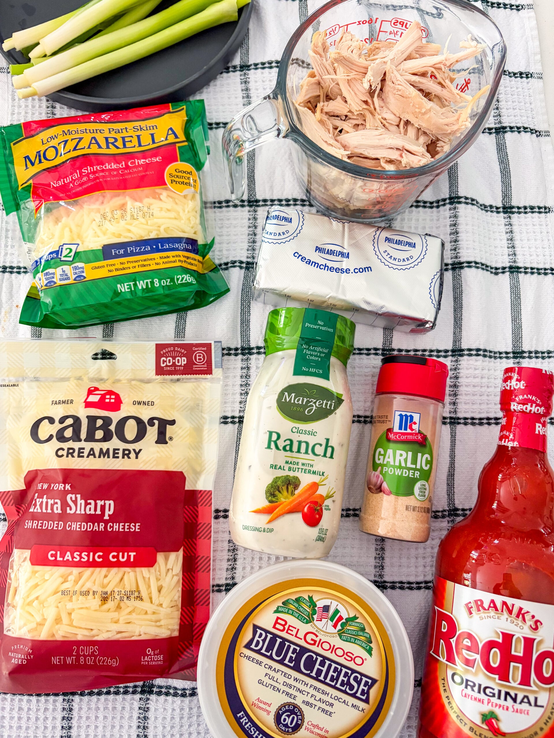 Buffalo chicken dip recipe ingredients laid out on dish towel