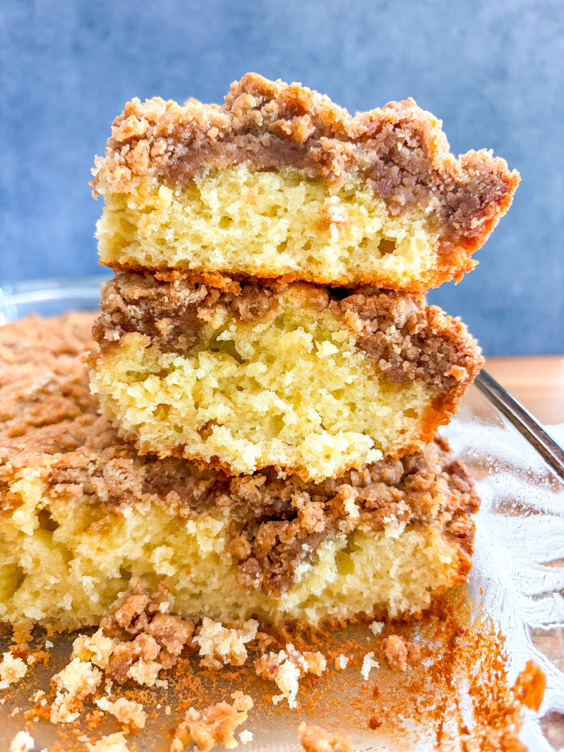 Coffee cake slices stacked on each in glass pan
