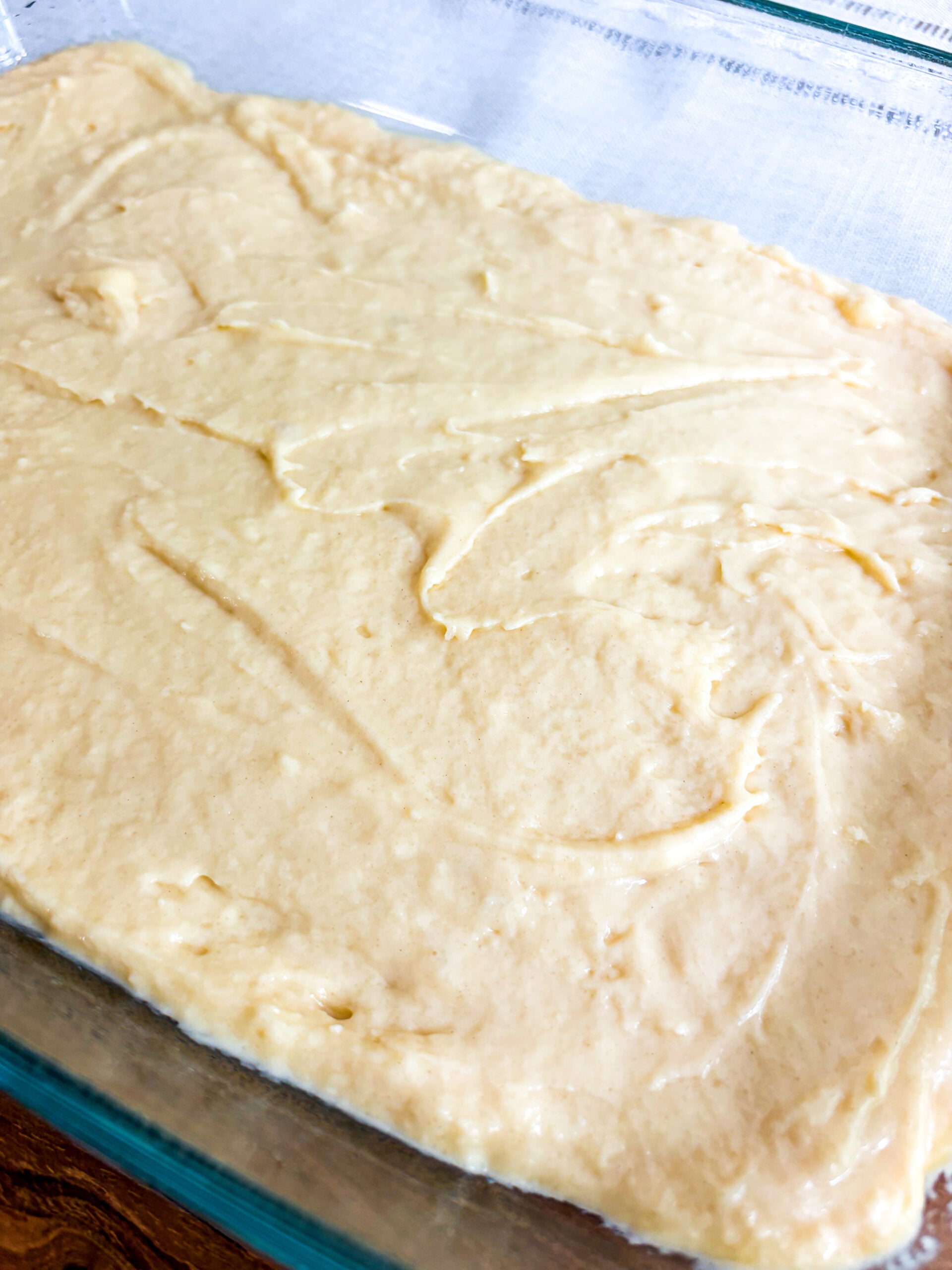 Cake batter spread out in glass pan