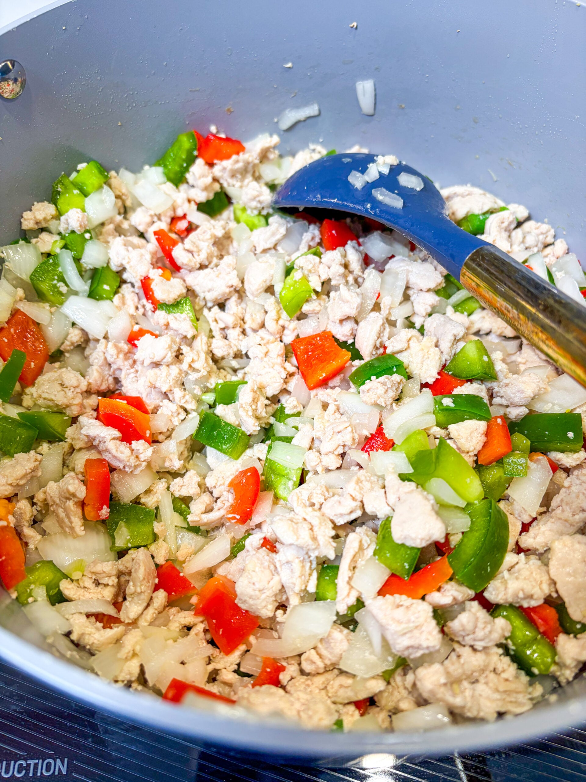 Ground chicken and veggies being sautéed in a pot
