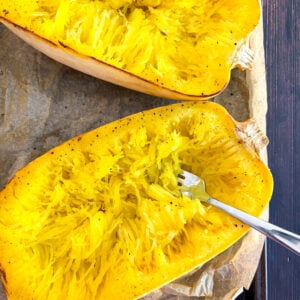 Halved spaghetti squash pulled into strands with fork