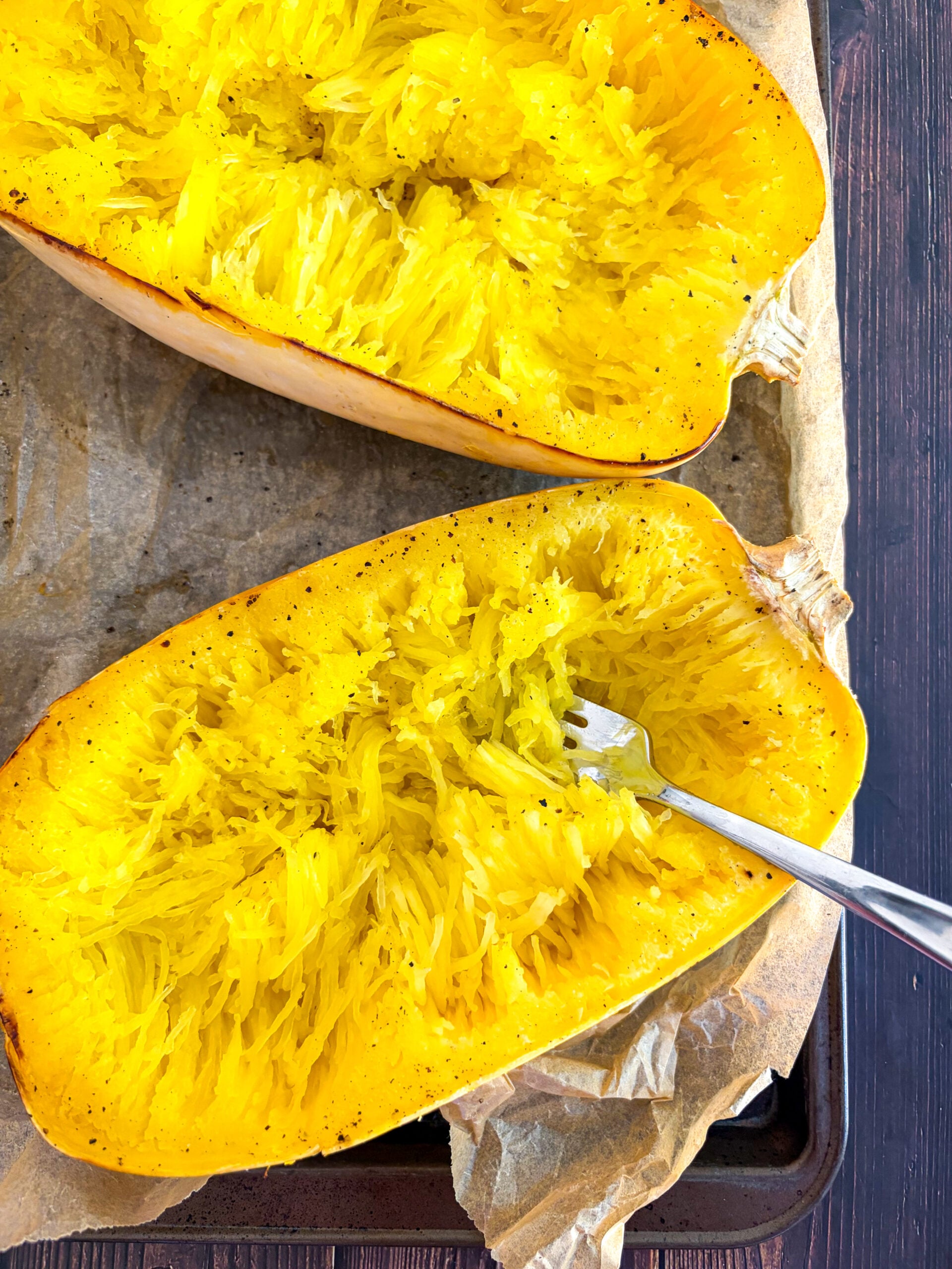 Halved spaghetti squash pulled into strands with fork