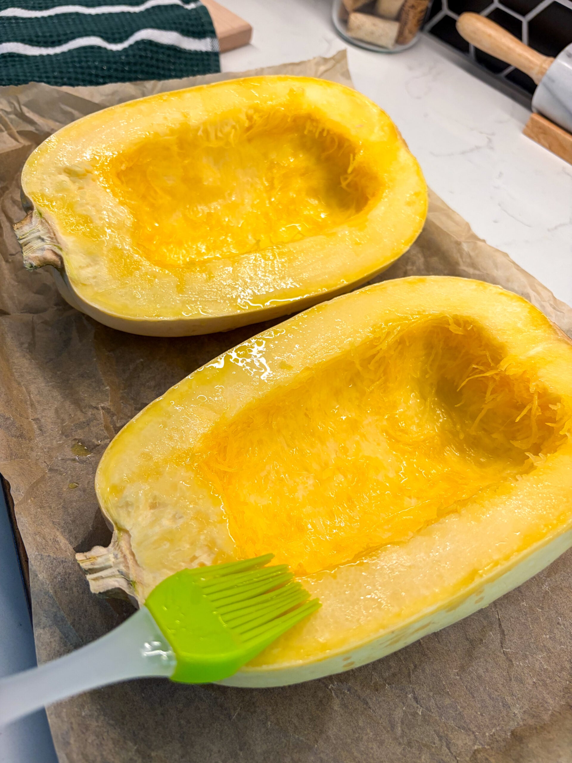 Brushing spaghetti squash halves with olive oil