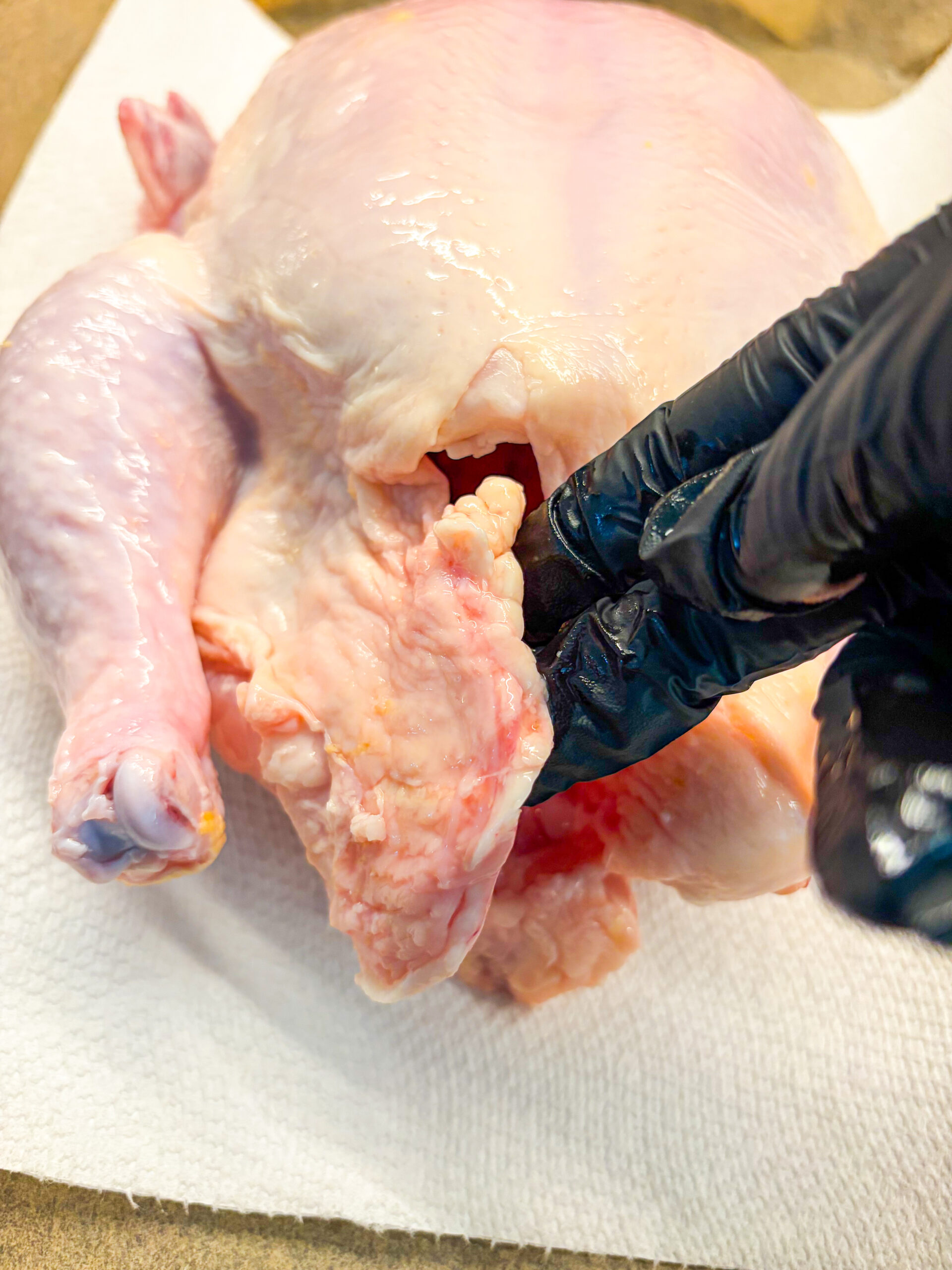 Pointing to loose fat flaps on chicken